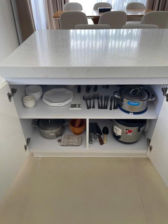a white cabinet filled with lots of kitchen utensils at Wyndham garden villa 304 in Cam Lâm