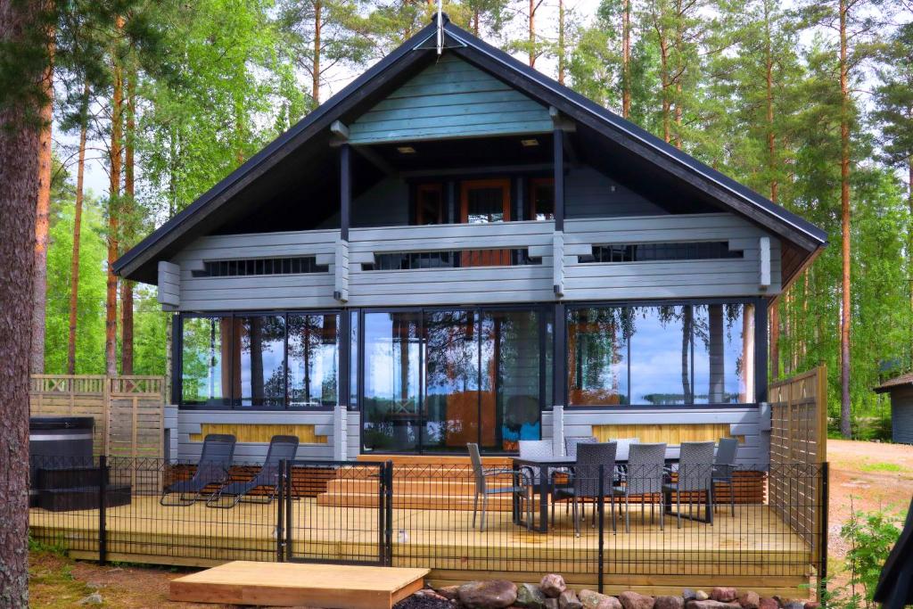a cabin in the woods with chairs and tables at Villa Alli in Siikainen