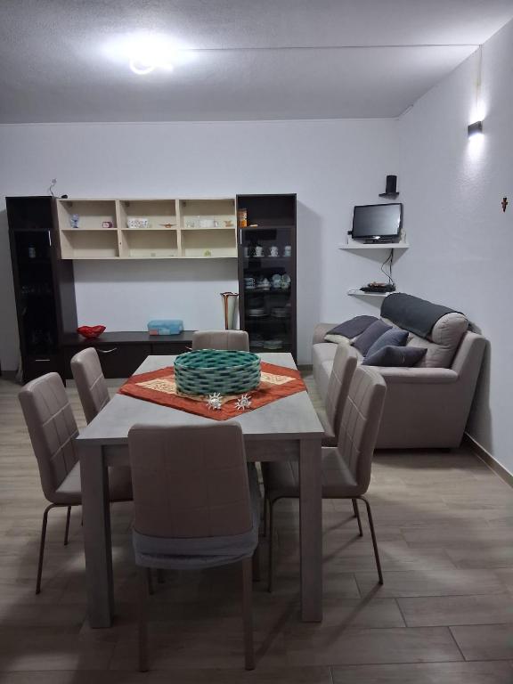 a living room with a table and chairs and a couch at Casamare Roby in Tanaunella