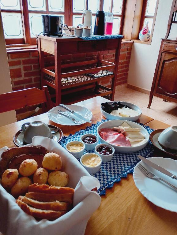a table topped with plates and bowls of food at Refúgio dos Pássaros in Gonçalves