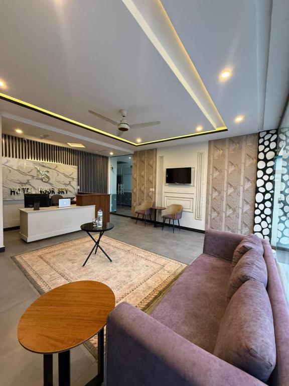a living room with a couch and a table at Hotel Noor Sky in Islamabad