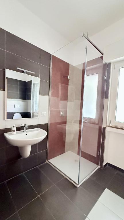 łazienka z przeszkloną kabiną prysznicową i umywalką w obiekcie The Palms w mieście Bari