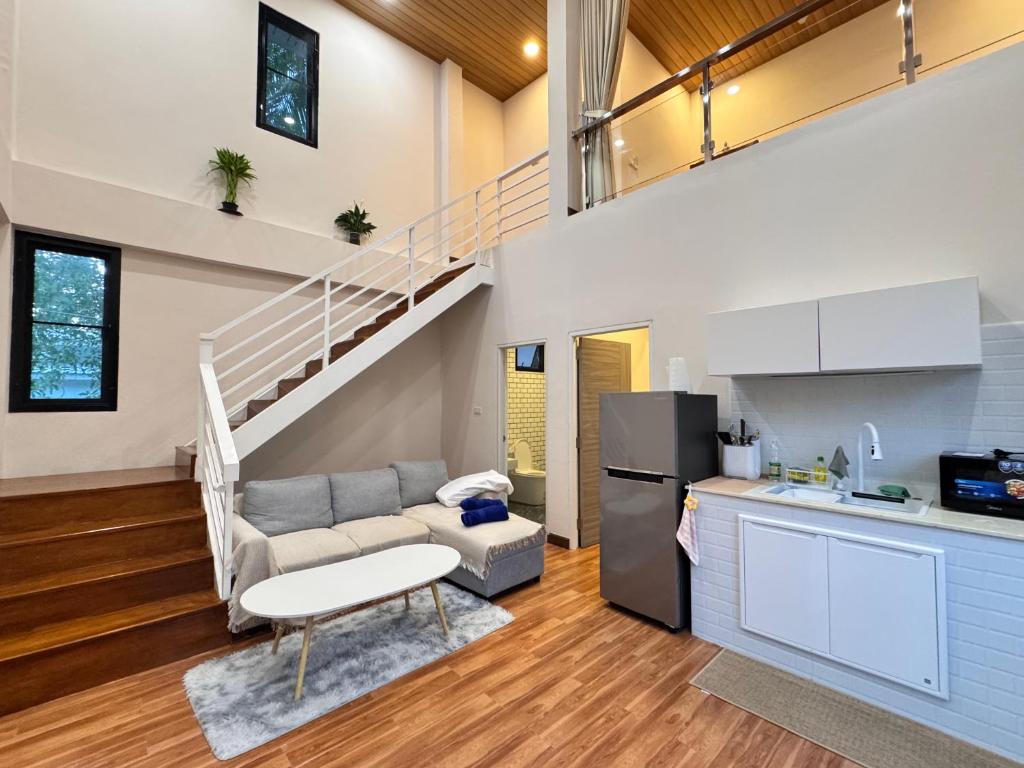 a living room with a couch and a staircase at Naruemon in Ban Madua Wan