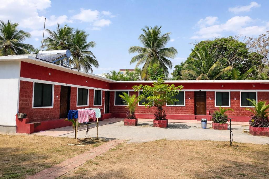a red and white building with clothes hanging outside at Manan Beach Resort in Malpe