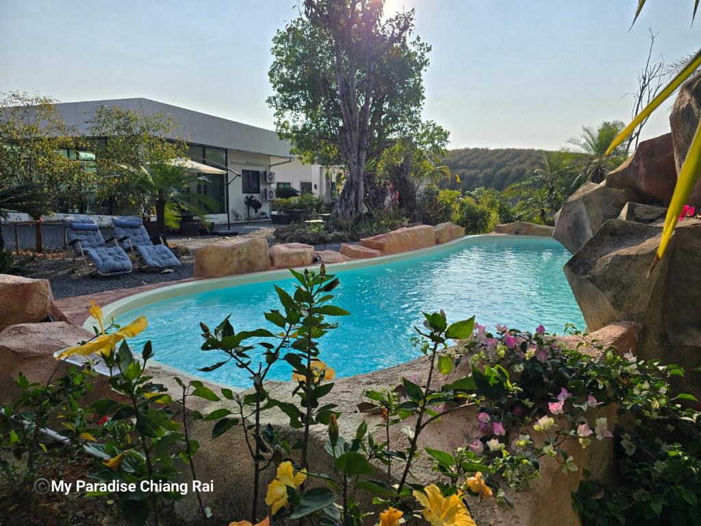 a swimming pool in a yard with rocks at My Paradise Boutique Eco Resort Chiang Rai in Chiang Rai