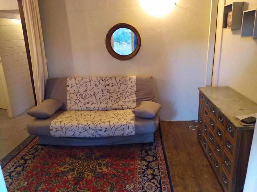 a small living room with a couch and a mirror at Gîte nature sous les châtaigniers in Zonza