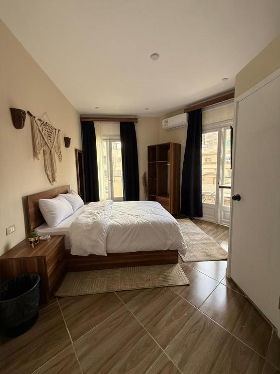 a bedroom with a bed and a large window at Swisstay Downtown Cairo in Cairo