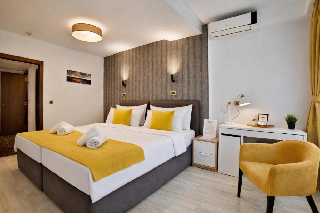 a bedroom with a large bed and a chair at Garni House 46 Plus in Belgrade