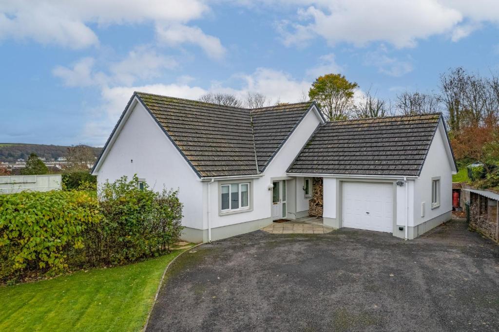 a white house with a garage at Llais Y Mor - large holiday home close to the beach - sleeps 8 in Carmarthen