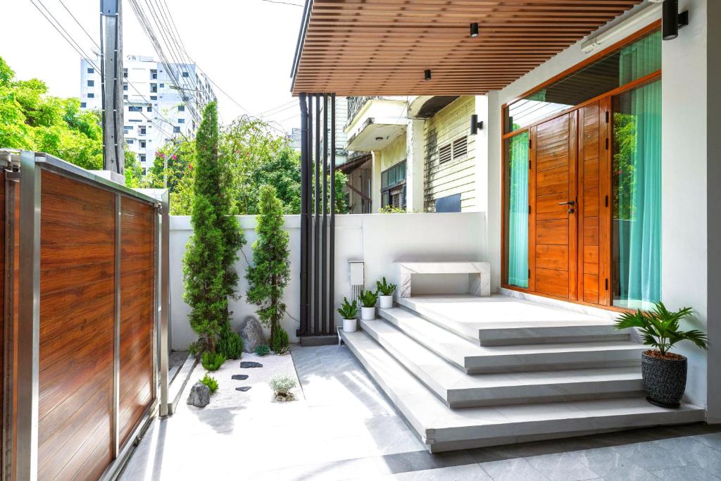 a home with a courtyard with a wooden door at Bhumidol Home near Don Muang Airport in Lak Si