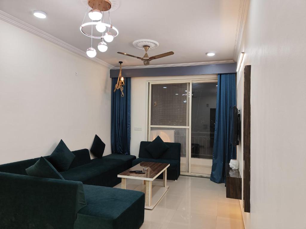 a living room with a couch and a table at Staeg Meadow View 3BHK - 501 in Indore