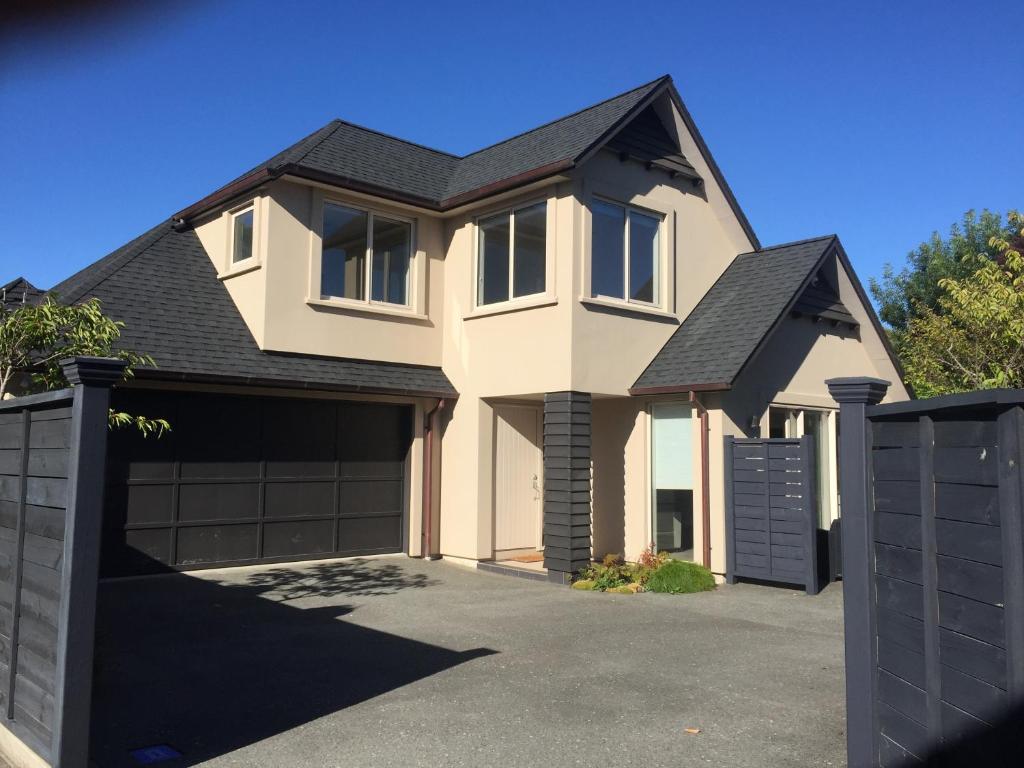 une maison blanche avec un garage dans l'établissement Davidsons Luxury Homestay, à Lower Hutt