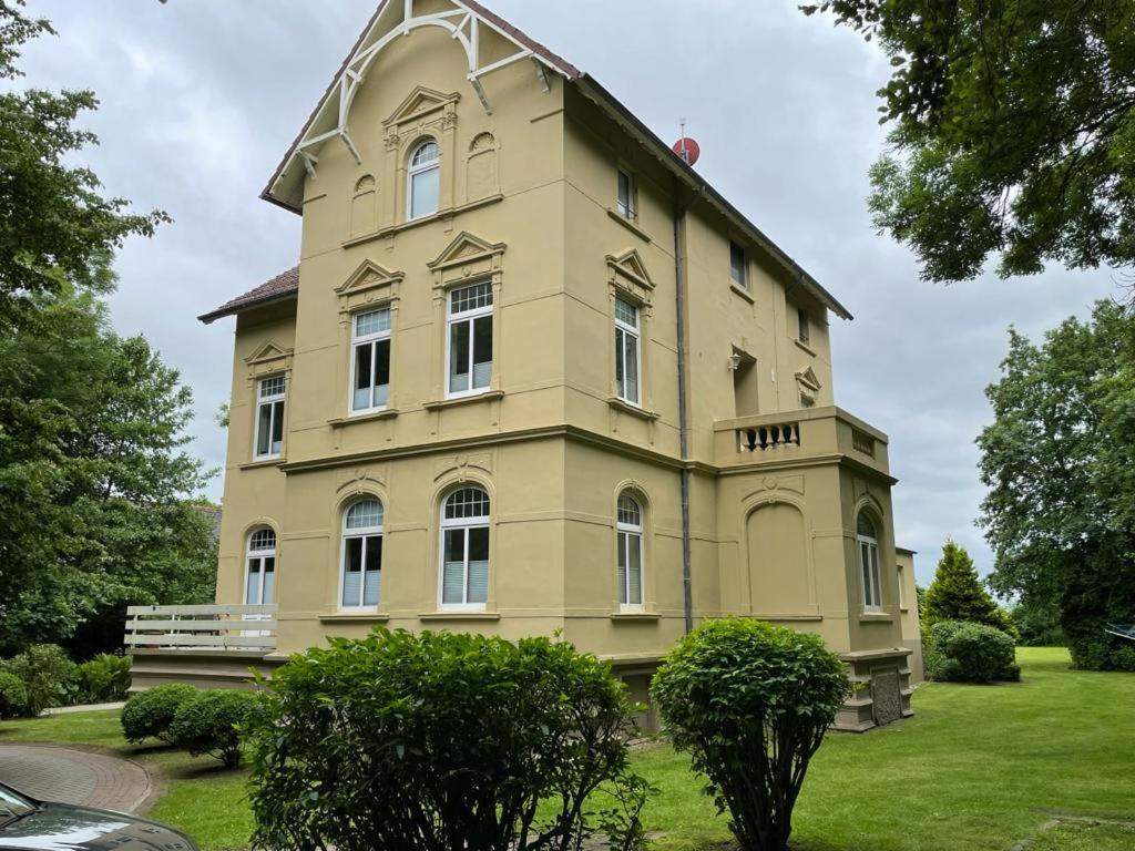 a large yellow building with a gambrel at Villa Meeresglück in Dornum