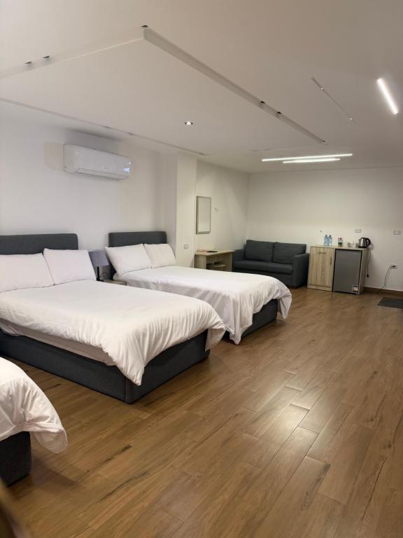 a hotel room with two beds and a couch at الحصرى Elhosary otel in 6th Of October