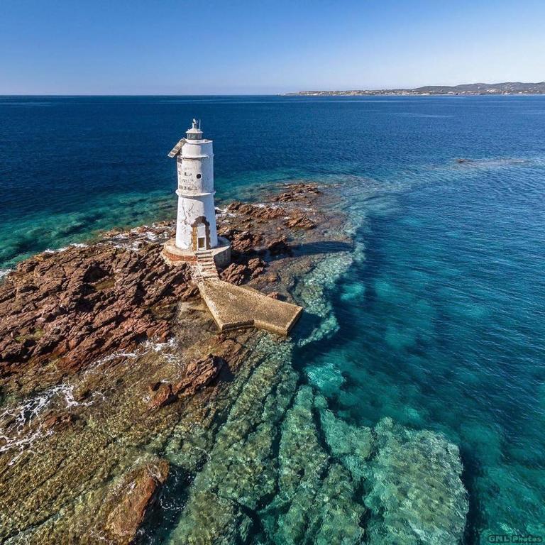 ein Leuchtturm auf einer felsigen Insel im Ozean in der Unterkunft Cal'e Sèda in Calasetta