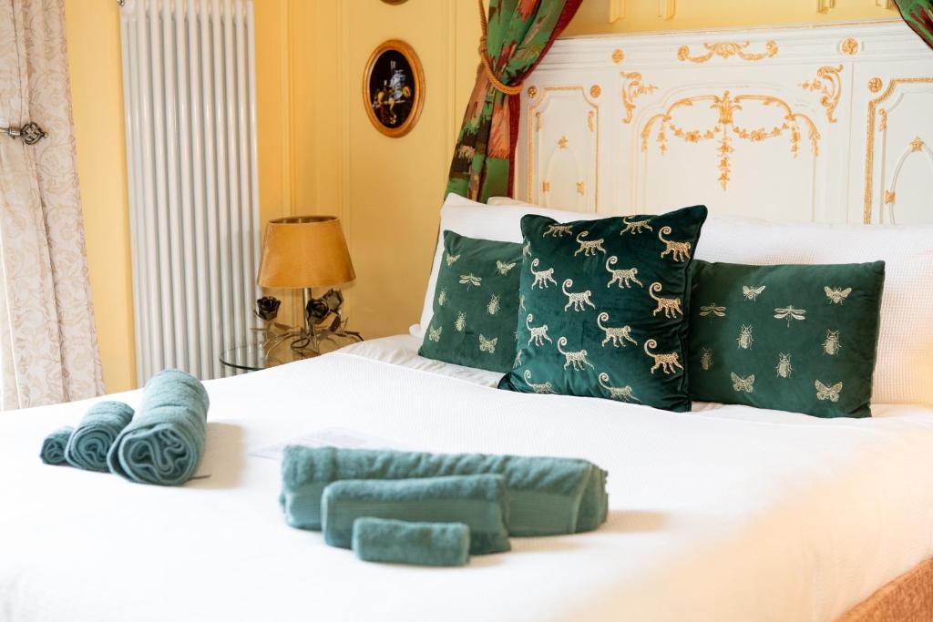 a bedroom with two beds with green and white pillows at Chez Vivienne in Ilkley