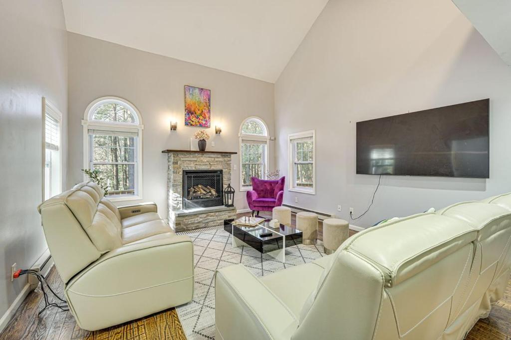 a living room with white furniture and a flat screen tv at Pocono nirvana in East Stroudsburg