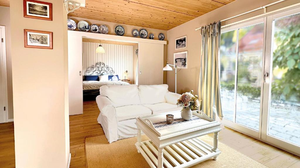 a living room with a white couch and a bed at Am Inselufer in Werder