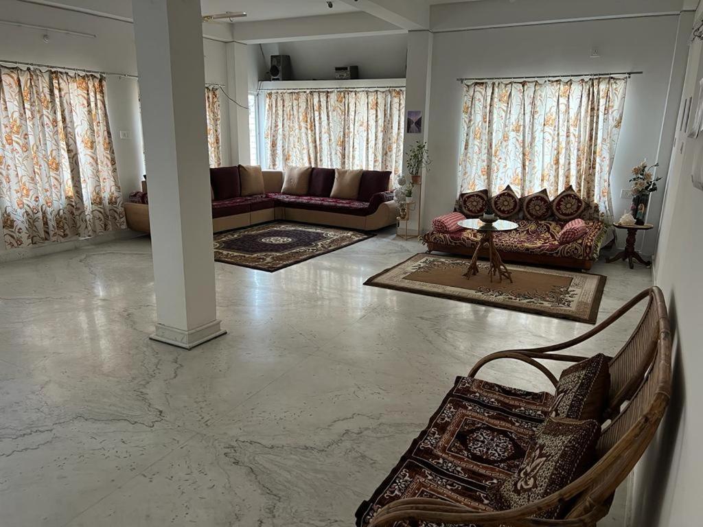 a large living room with couches and a couch at Pappu niwas in Siliguri
