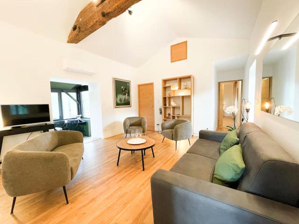 a living room with a couch and a table at Le Petit Rousseau - Maison Climatisé - Classé 4 ETOILES in Hurigny