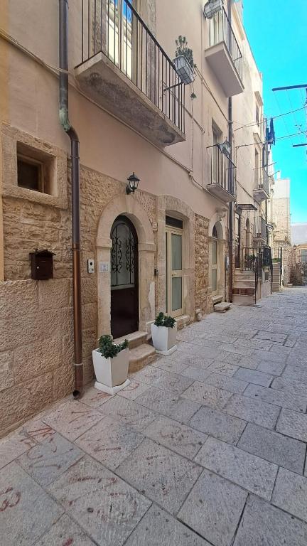 a building with two potted plants in front of it at Le Stanze sul Colle in Palo del Colle