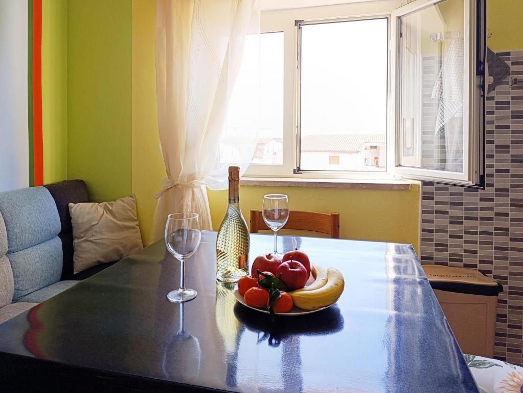 a table with a bowl of fruit and wine glasses at Casa Bonifacio in Scalea