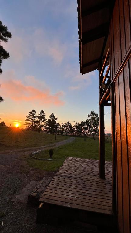 a porch of a house with the sunset in the background at Morada das Estrelas in Cambará