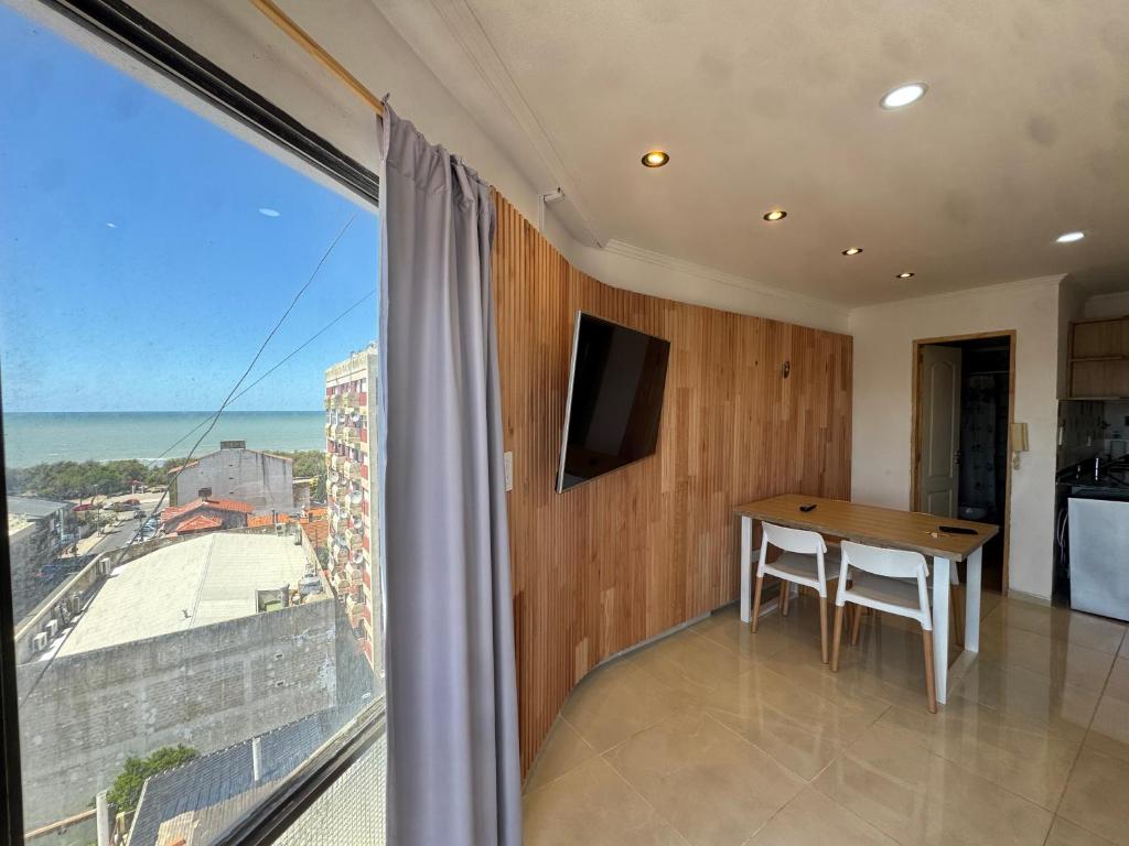 a dining room with a table and a large window at Panoramico in Santa Teresita