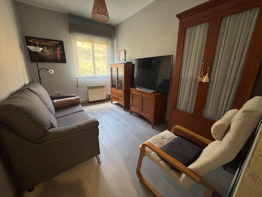 a living room with a couch and a tv at Norte Astur in Langreo