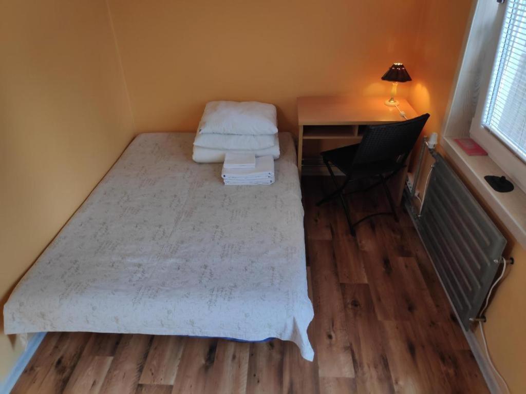 ein kleines Zimmer mit einem Bett und einem Schreibtisch mit einem Laptop in der Unterkunft Forrent-ee in Pärnu