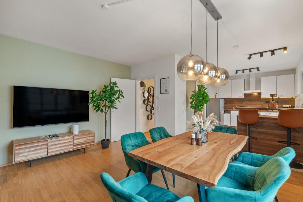 a living room with a wooden table and blue chairs at dreamfactory Residences - Wine Escapes # 3BR Suite in Langenlois