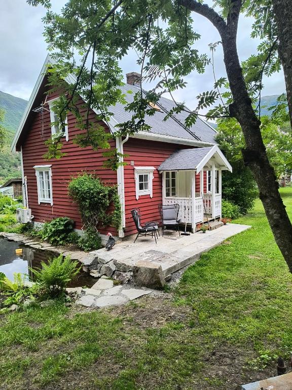 a red house with a porch and a patio at Flintegården Kårhus in Borgund