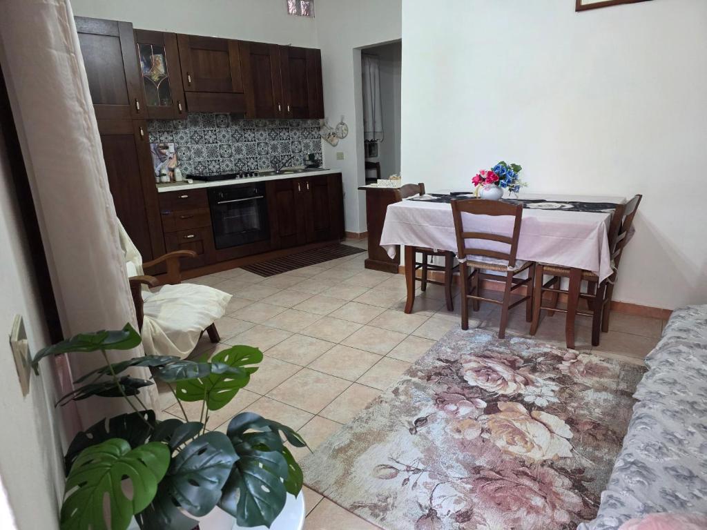 a living room with a table and a kitchen at Casa Grilla in Assemini