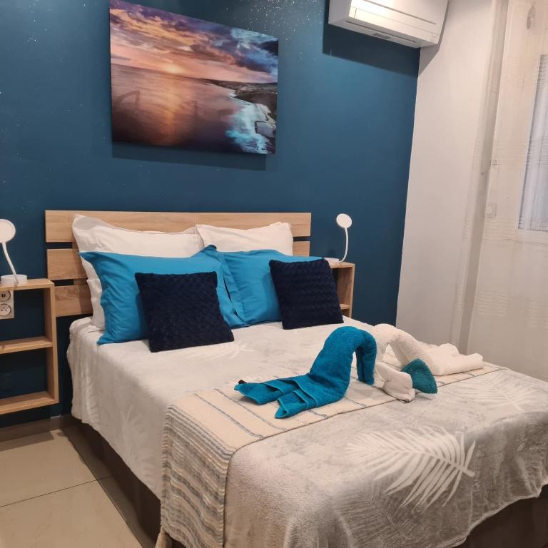 a bedroom with a large bed with blue walls at Le Pavillon du trou d'eau in La Saline les Bains