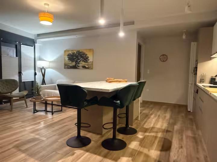 a kitchen and living room with a table and chairs at Central & Beautiful in Sitia