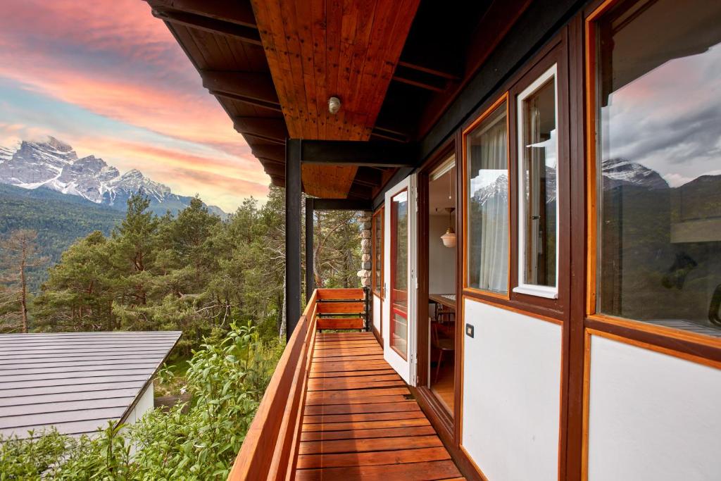 a house with a balcony with a view of mountains at Modernist Chalet in Borca di Cadore