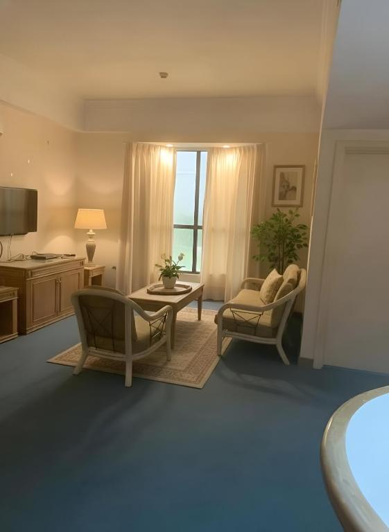 a living room with a couch and a table and chairs at 2BR Seaview Condo with Balcony at Riviera Bay Resort, Melaka in Malacca