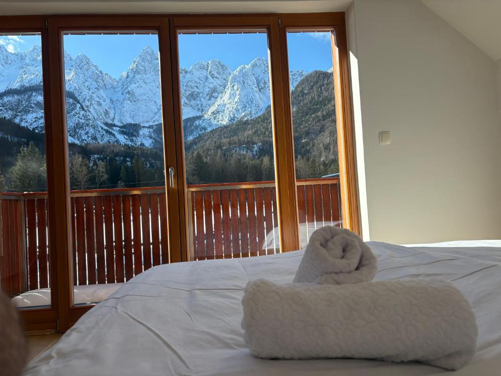 a bed with a towel on it with a view of mountains at Apartment Barbara with sauna in Gozd Martuljek