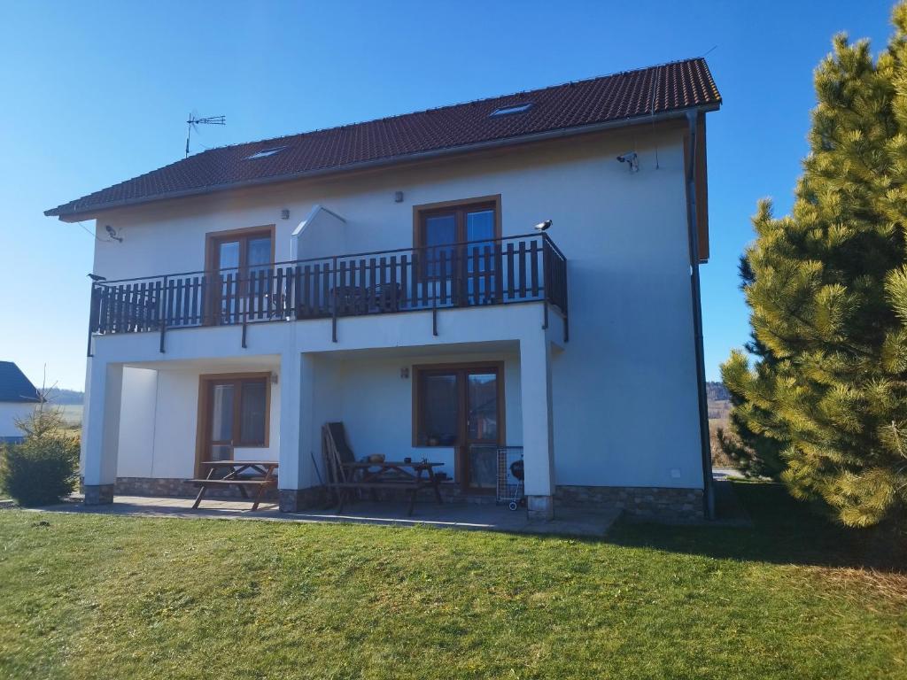 a large white house with a balcony and a yard at Apartmán Adam in Dolní Moravice