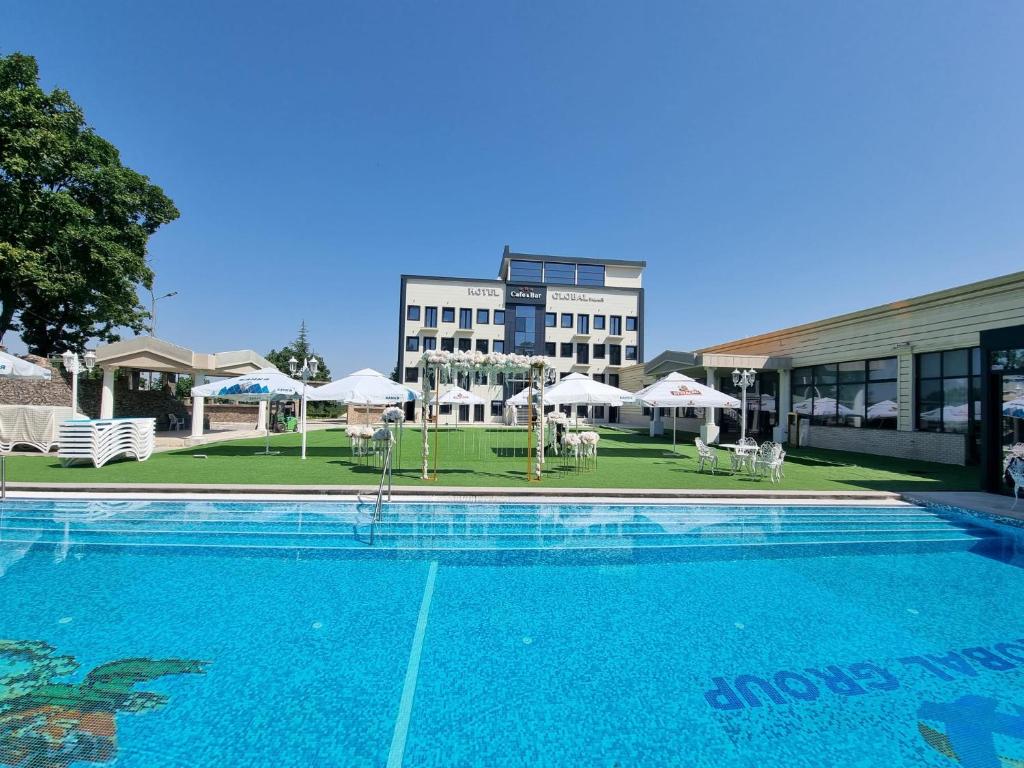 a large swimming pool in front of a building at Hotel Global Palace in Haskovo