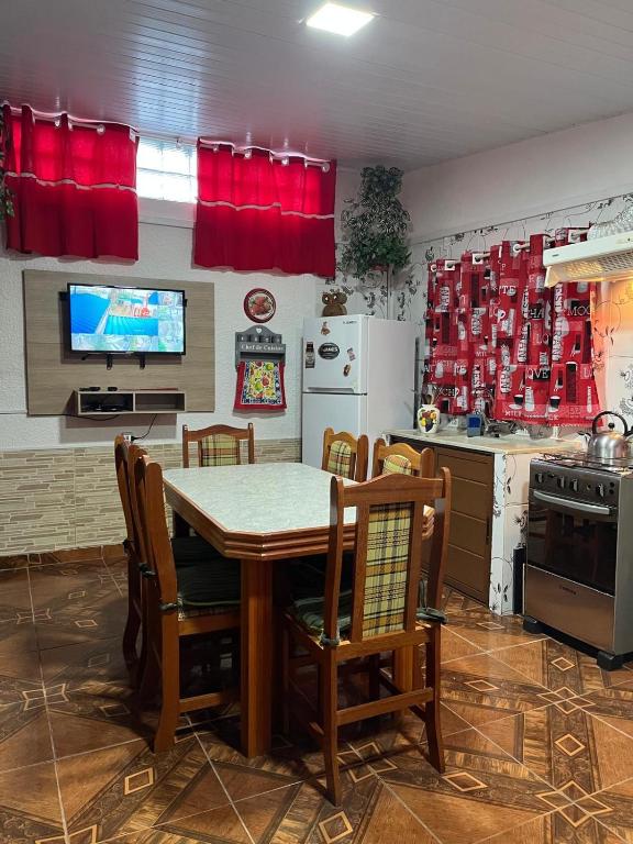 a kitchen with a table and chairs and a television at La Dorada in Barra del Chuy