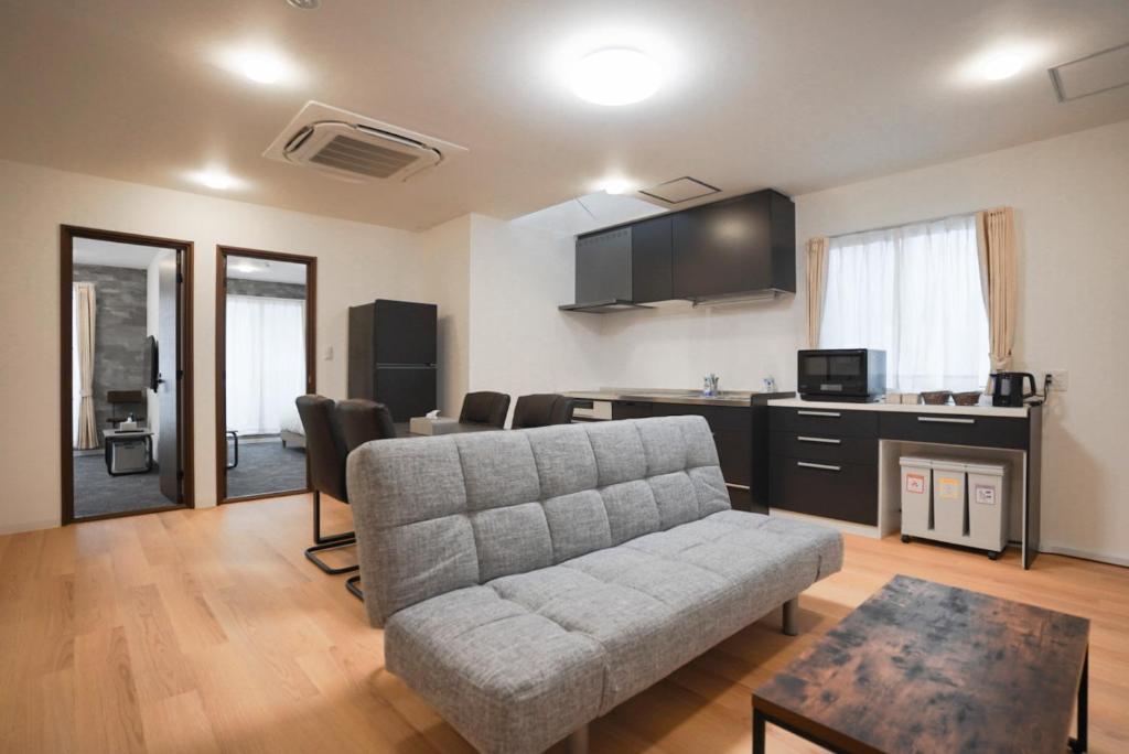 a living room with a couch and a table at Laon Inn Plus Miyakojima in Miyako-jima