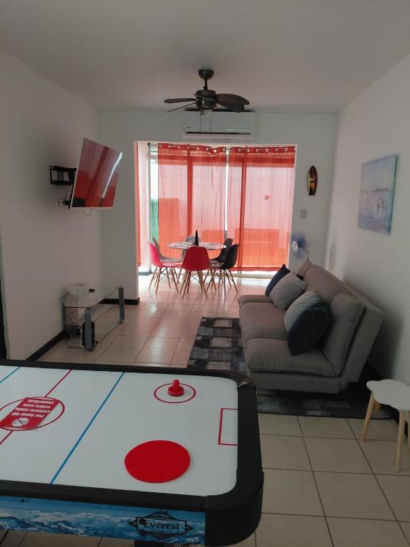 a living room with a couch and a table at Sunset House Herradura in Herradura