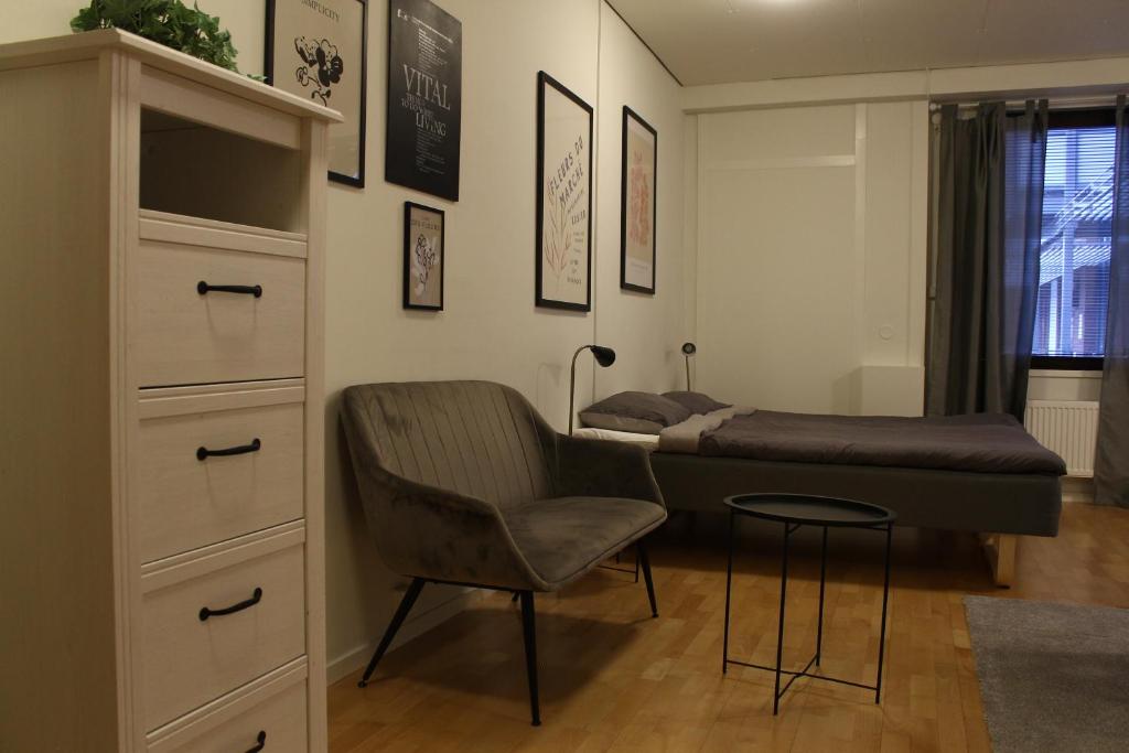 a bedroom with a bed and a chair and a dresser at Vandrarhemmet Eken in Eksjö