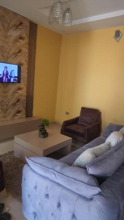 a living room with a couch and a tv at The Oasis in Ilorin