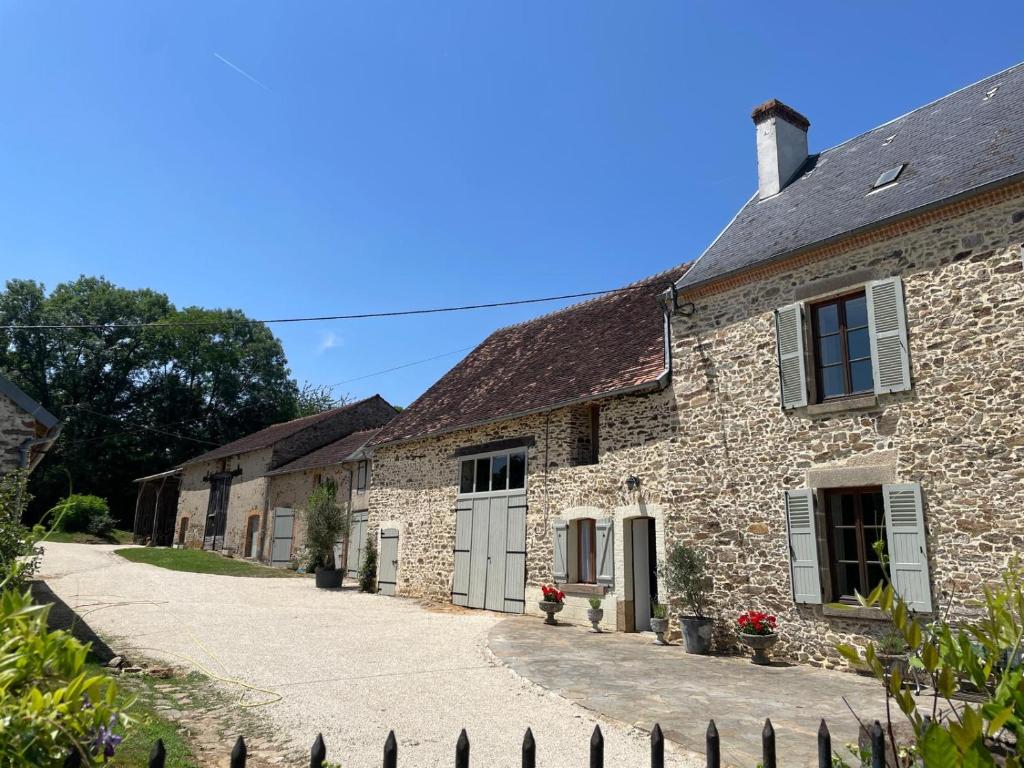 an old stone house with a driveway at Georgie et Margot - Chambres d'hotes et Gite in La Châtre-Langlin