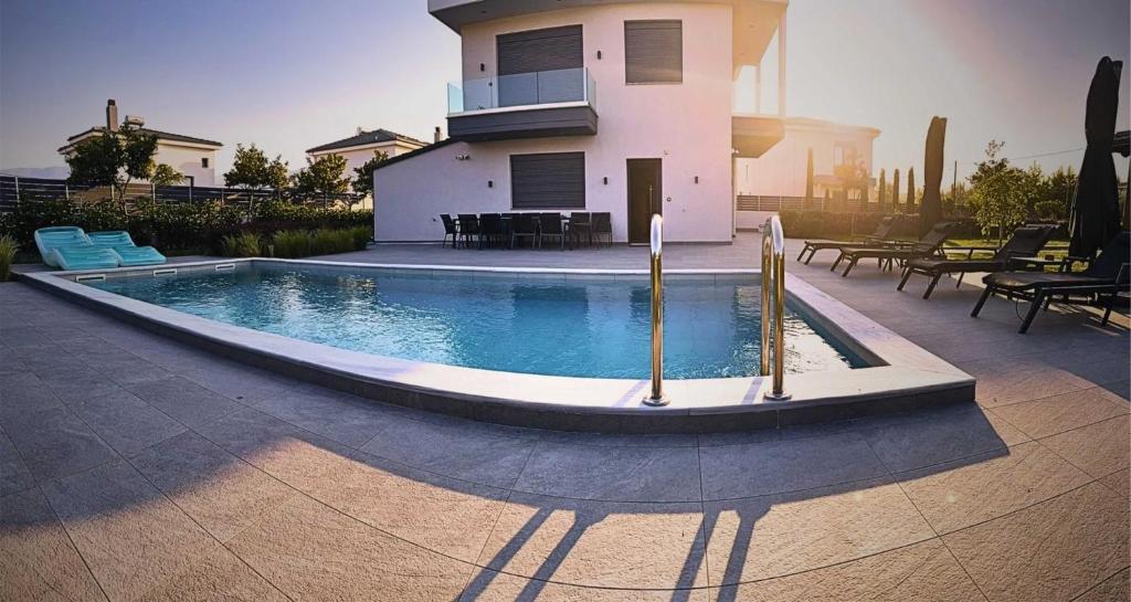 a swimming pool in front of a house at Luxury Villa Plaka Litochorou with Pool in Plaka Litochorou