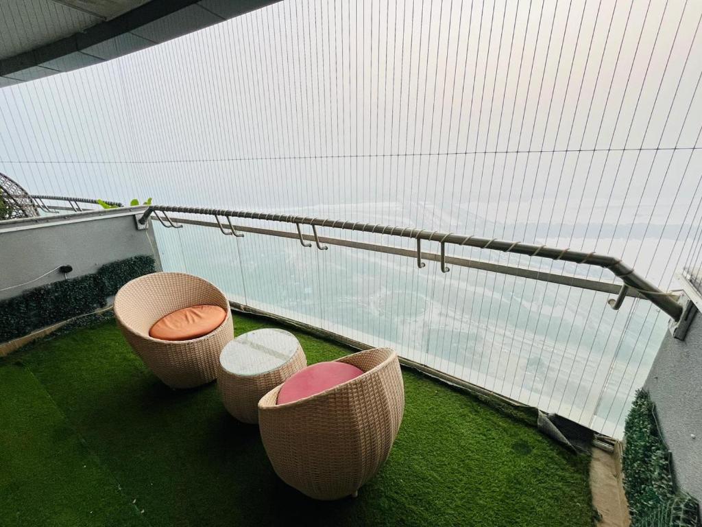 a balcony with three chairs and a railing at Landin2home studios in New Delhi