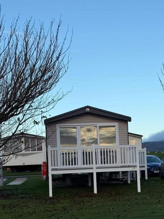 a small house with a large window on a porch at Paws A While in Mainsriddle