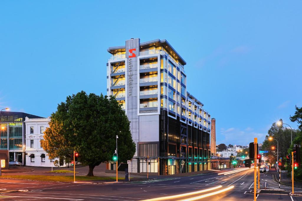 Un palazzo alto in una strada di città di notte di Swiss-Belsuites Victoria Park Auckland ad Auckland